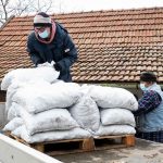 Az önkormányzati dolgozók lepakolják a barnakőszenet egy csabacsűdi családi ház udvarán (Fotó: Babák Zoltán)