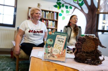 A Nem mind arany, ami férfi című könyv, mögötte balról a szerző, Majernyik Szimonetta, illetve beszélgetőtársa, Kreisz Andrea