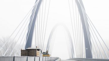 Munkagépek haladnak át angolosan az M44-es új Tisza-hídján 2021. december 15-én