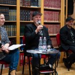 Turcsányi Lajos a Városi Könyvtárban 2022. május 2-án. Balról beszélgetőtársa, Hegedűs Éva, jobbról zenésztársa, Felföldi Zsolt.