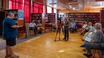 Tatai László, a Szarvasi Krónika felelős szerkesztője tallóz a kiadvány fejezetei között 2023. június 30-án a Városi Könyvtárban tartott bemutatón.