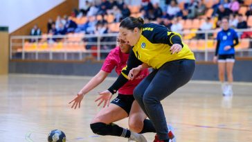 Milyó Alexandra (pink-fekete, Szarvasi NKK) és Fodor Edit kapus (sárgában K. Szeged) küzdelme a labdáért.