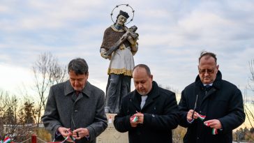Nepomuki Szent József szobra figyeli, ahogy Kozák János, Sinka Imre és Rusz Mihály átvágja a szalagot.