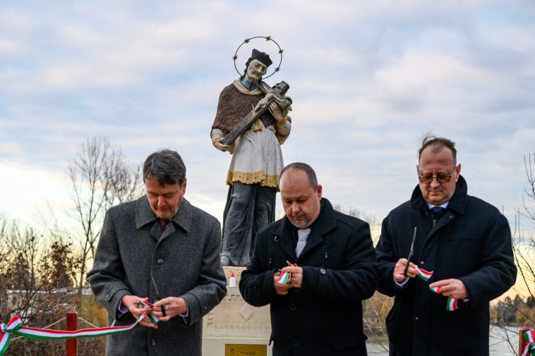 Nepomuki Szent József szobra figyeli, ahogy Kozák János, Sinka Imre és Rusz Mihály átvágja a szalagot.