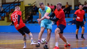 Barta Gábor és Seres Viktor (pirosban, Gólgyártók) igyekszik megakadályozni Kozák Balázst (türkizben, ProGym) a kapuralövésben.