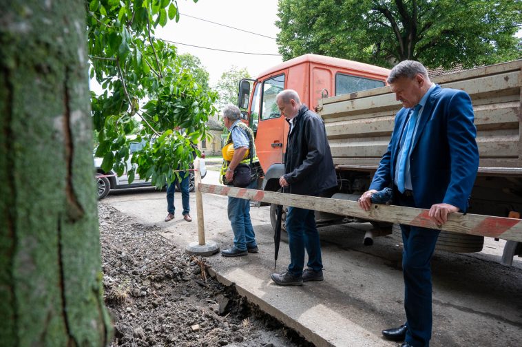 Hodálik Pál polgármester és Závoda Ferenc képviselők szemlélik a Bem József utcán folyó munkálatokat.