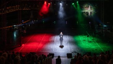 A Szent Mihály-napi tűzgyújtás kultúrprogramjában fellépő Csonka Dóra mögött a Napkorongos Csodaszarvas látható.