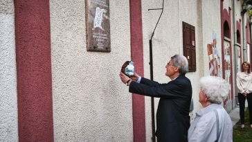 Czuczi Ernő, a Szőnyeggyár korábbi vezetője koszorút helyez el az emléktáblánál.