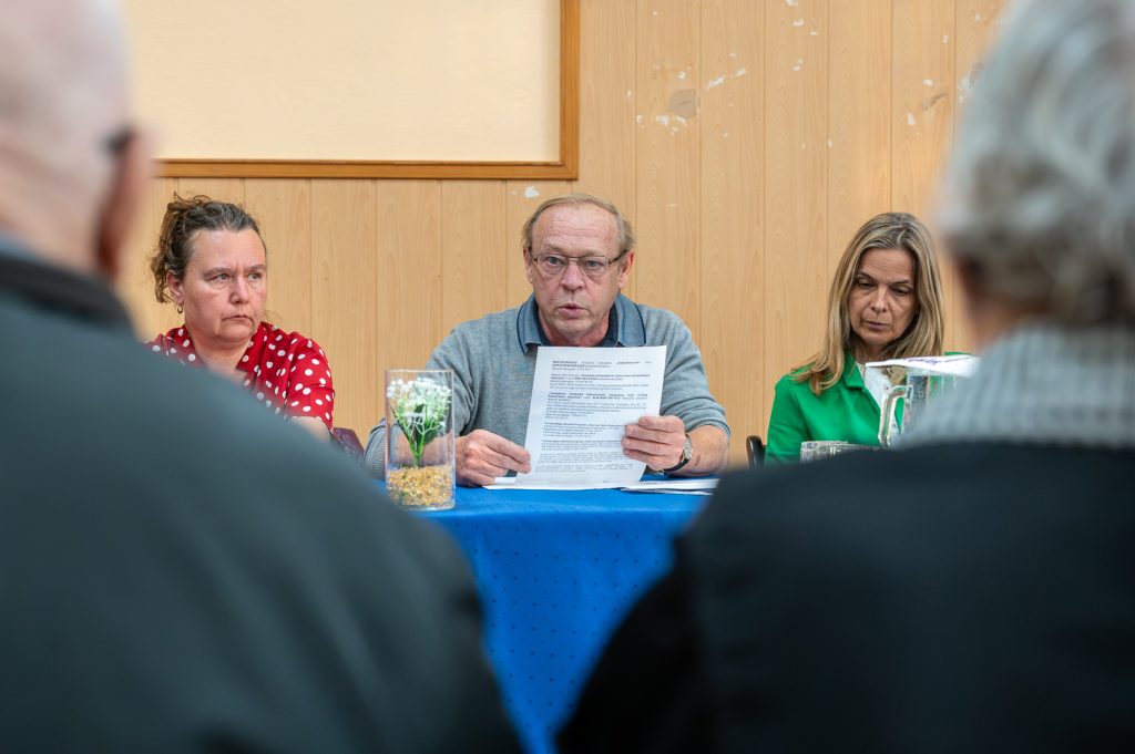 A közmeghallgatáson Molnár József polgármester tájékoztatja az érdeklődőket. Mellette balról Szilágyi Bernadett képviselő, jobbról Lénártné dr. Belicza Györgyi aljegyző. Háttal az érdeklődők.